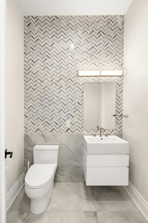 a bathroom with a sink a toilet and a mirror