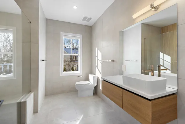 a bathroom with a sink a toilet and a mirror