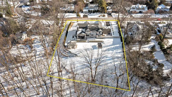 a front view of a house with large trees