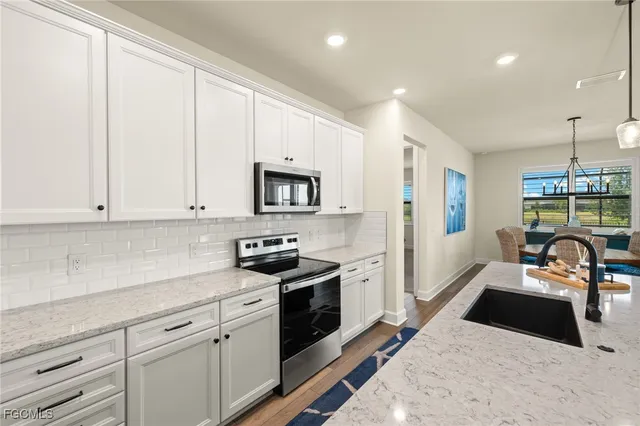 a kitchen with granite countertop white cabinets and white appliances