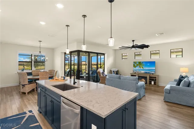 a kitchen with a counter top space a sink appliances and wooden floor
