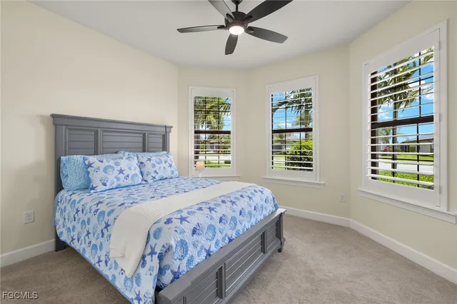 a bedroom with a large bed and two windows