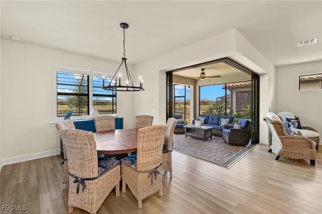 a dining room with furniture a chandelier and wooden floor