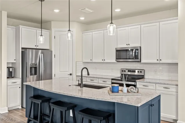 a kitchen with kitchen island granite countertop a sink a center island and cabinets