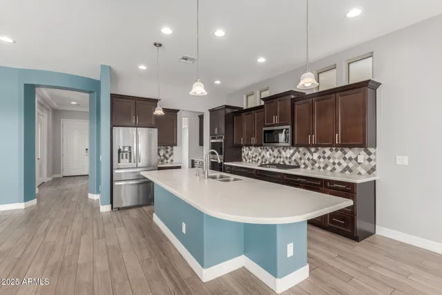 a kitchen with stainless steel appliances granite countertop a sink stove and refrigerator