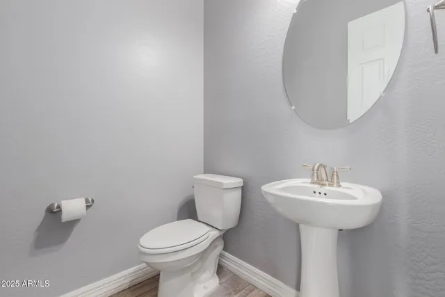 a bathroom with a sink a toilet and mirror