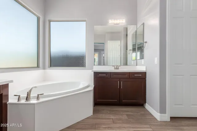 a bathroom with a tub sink and mirror