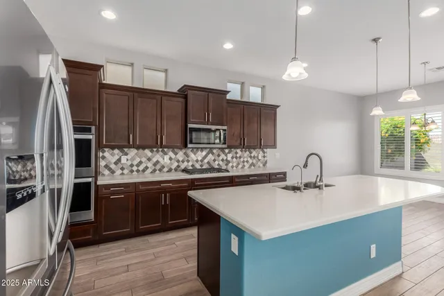 a kitchen with stainless steel appliances a sink stove and refrigerator