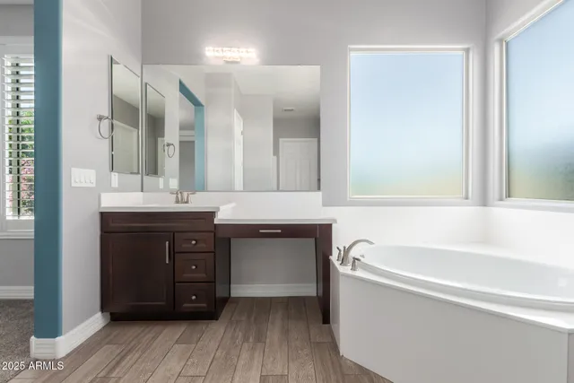 a bathroom with a tub sink and mirror