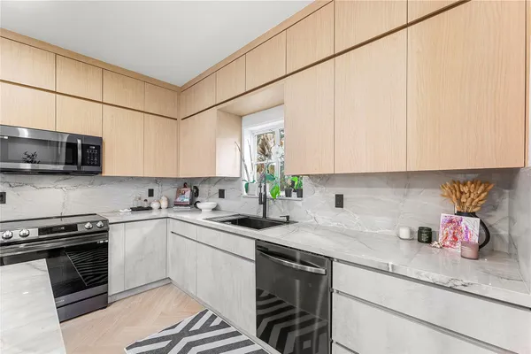 a kitchen with stainless steel appliances granite countertop a sink stove and microwave