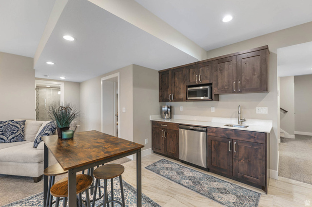 4527 North Seven Bridges Road Eden, UT 84310 - Photo 64 of 65 Kitchen with dark wood finish cabinets, recessed lighting, stainless steel appliances, open floor plan, and light stone countertops