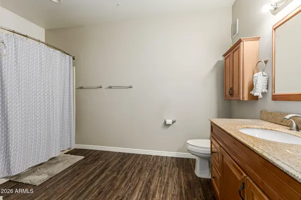 a bathroom with a granite countertop sink toilet and a mirror