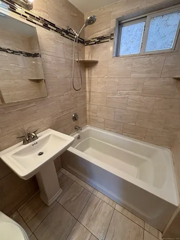 a bathroom with a sink mirror and a bathtub