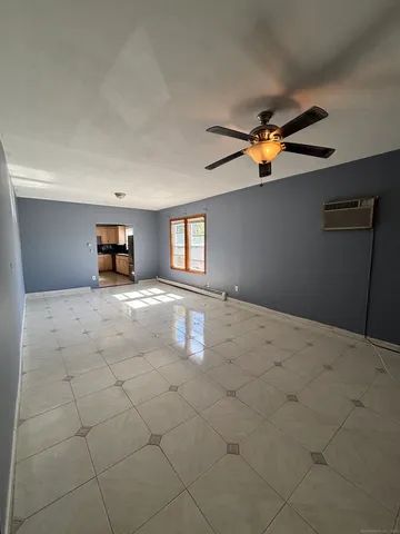 a view of a livingroom with a ceiling fan and window