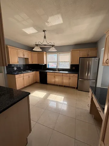 a kitchen with stainless steel appliances granite countertop a sink and a stove