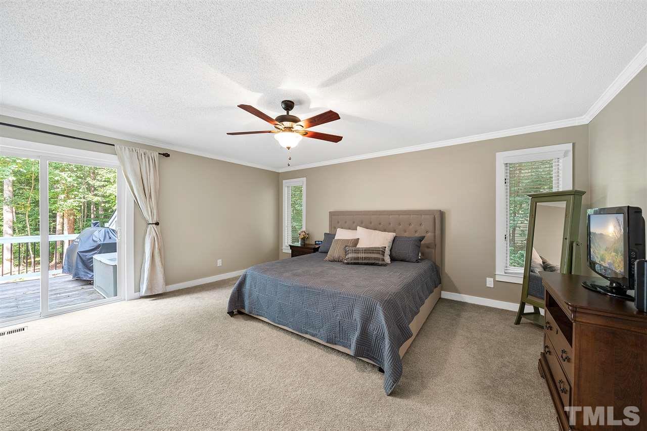 8609 Langtree Lane Raleigh, NC 27613 - Photo 14 of 30 a living room with a bed furniture and a flat tv screen