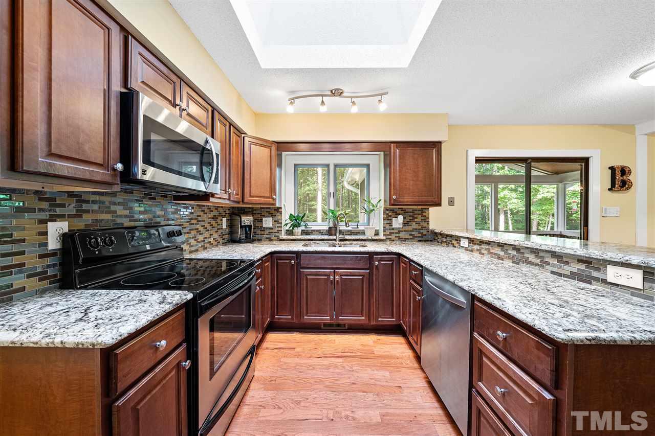 8609 Langtree Lane Raleigh, NC 27613 - Photo 9 of 30 a kitchen with stainless steel appliances granite countertop sink stove top oven and cabinets