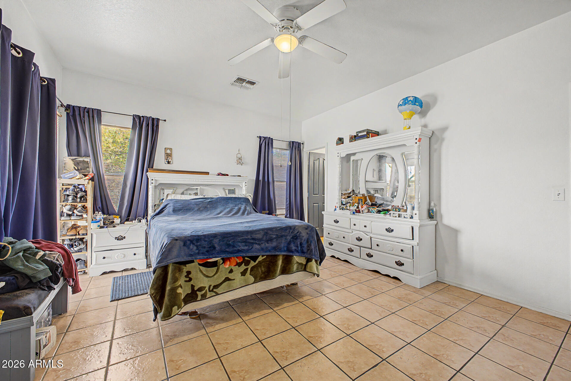 9730 West Payson Road Tolleson, AZ 85353 - Photo 15 of 57 a bedroom with a bed and a chandelier