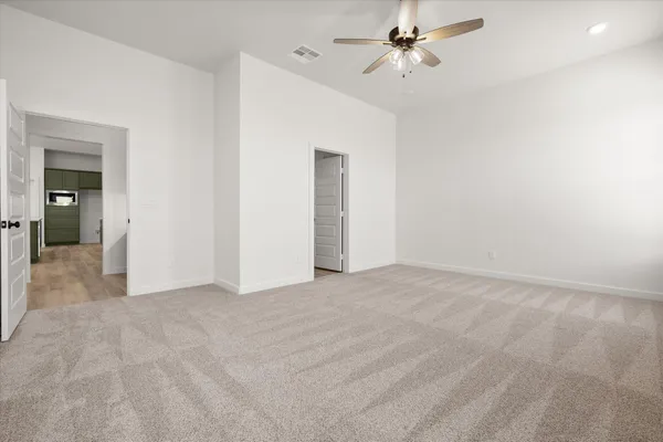 an empty room with windows and fan