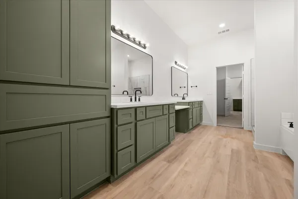 a spacious bathroom with a double vanity sink and mirror