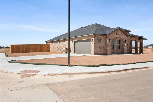 a view of a house with a small yard and fence
