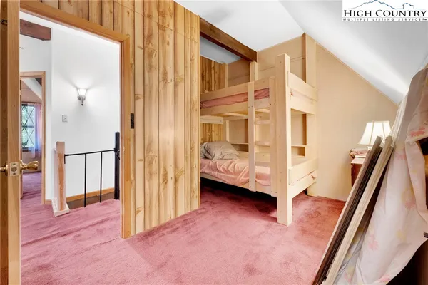 a bedroom with a bed and a dresser with mirror