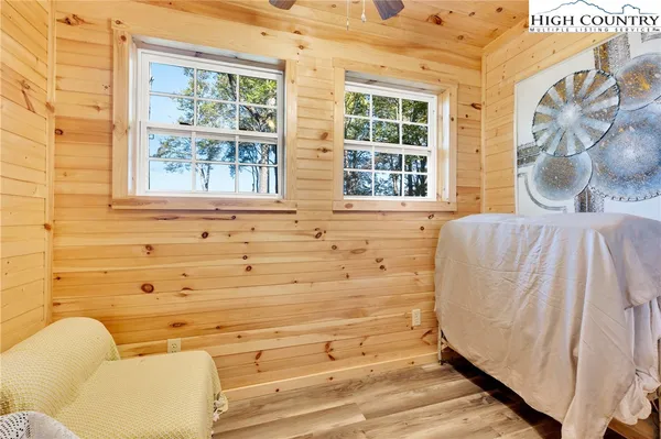 a bedroom with a bed and a dresser with wooden floor