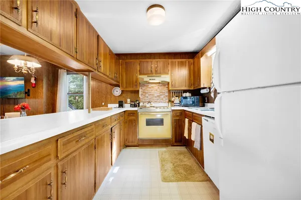 a kitchen with white cabinets and white appliances