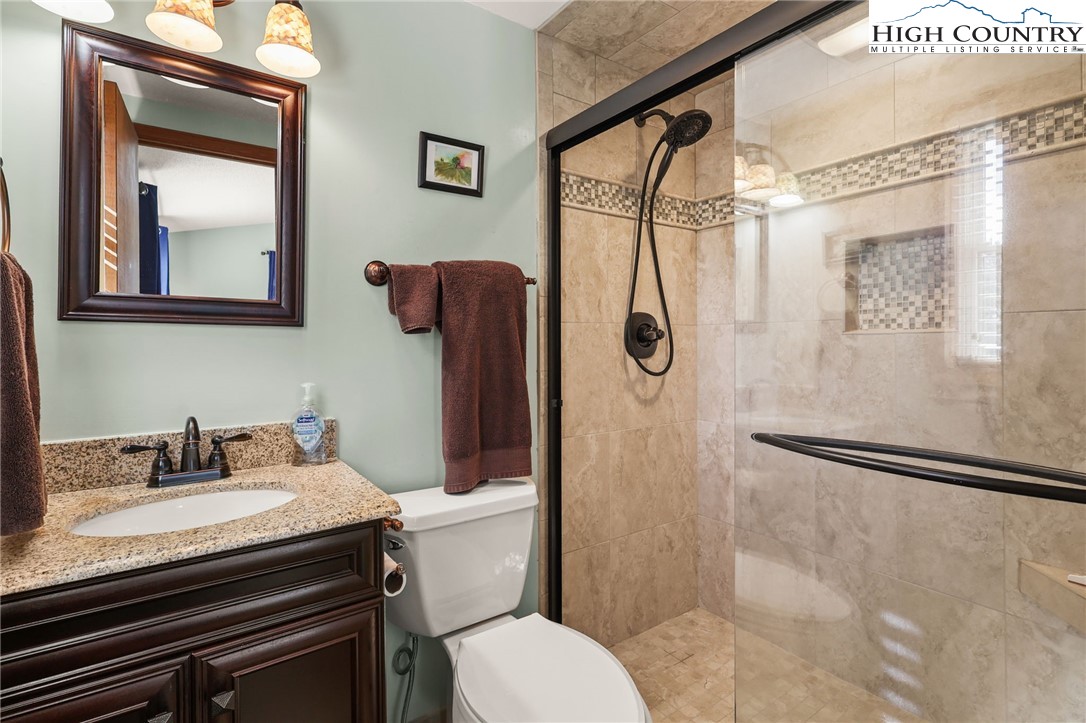 228 Snowshoe Loop Newland, NC 28657 - Photo 23 of 50 a bathroom with a granite countertop sink toilet and shower