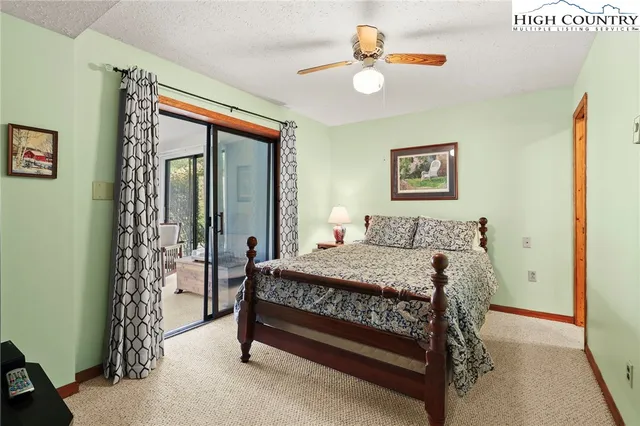 a bed sitting in a bedroom next to a window with a bookshelf