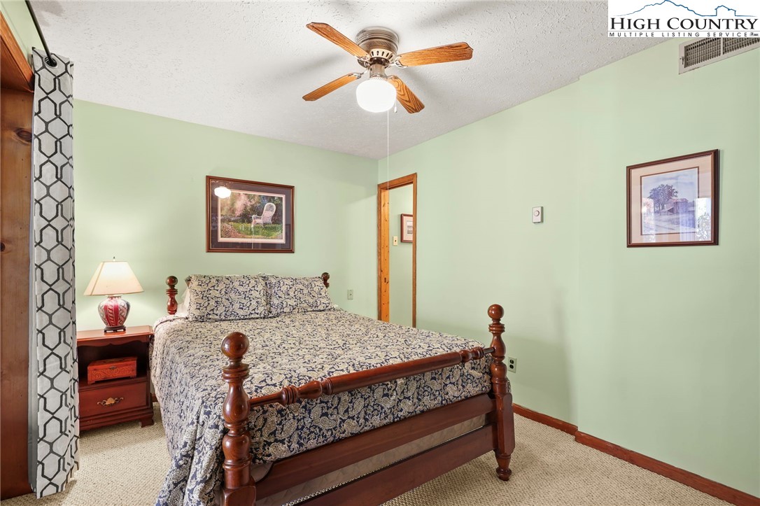 228 Snowshoe Loop Newland, NC 28657 - Photo 31 of 50 a bed sitting in a bedroom next to a window with a bookshelf