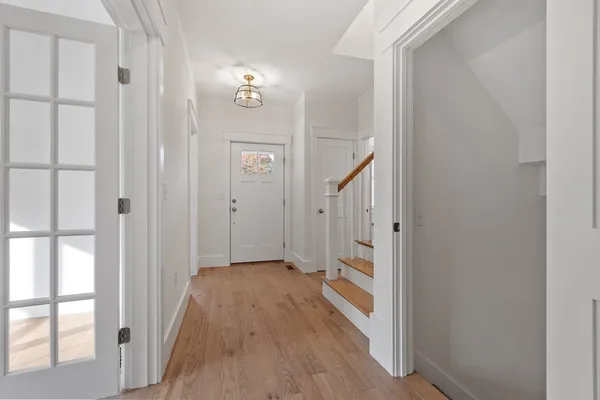 a view of a hallway with wooden floor and staircase