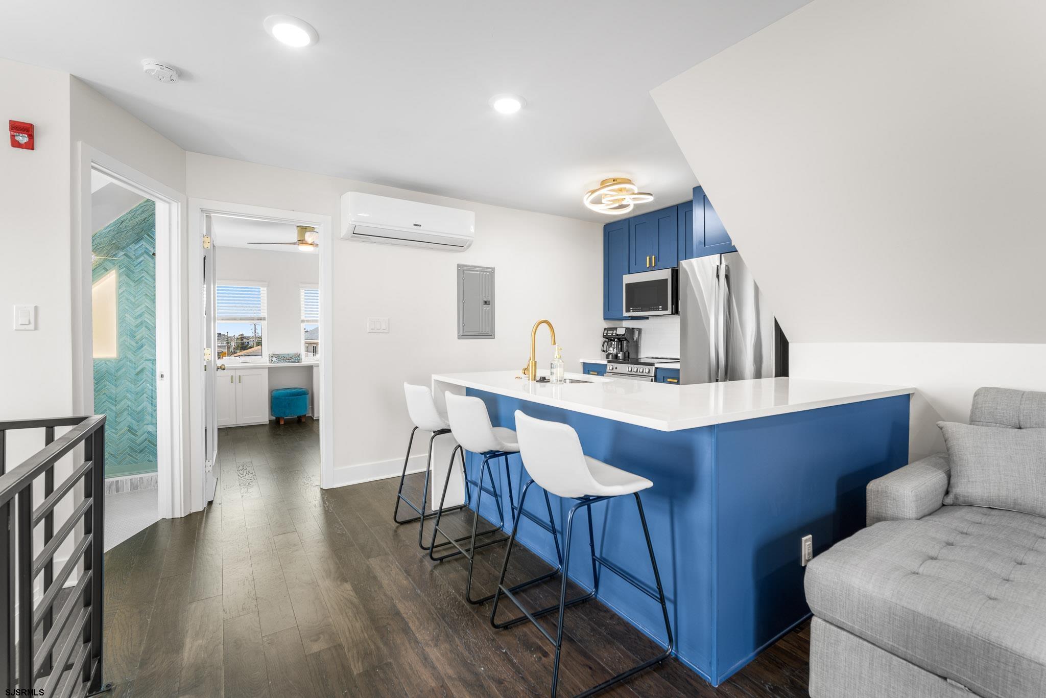 1059 Asbury Avenue, Unit 3 Ocean City, NJ 08226 - Photo 14 of 14 a kitchen with stainless steel appliances a dining table chairs and a refrigerator