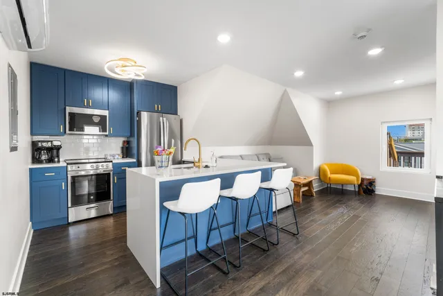 a kitchen with stainless steel appliances a sink a stove a table and chairs
