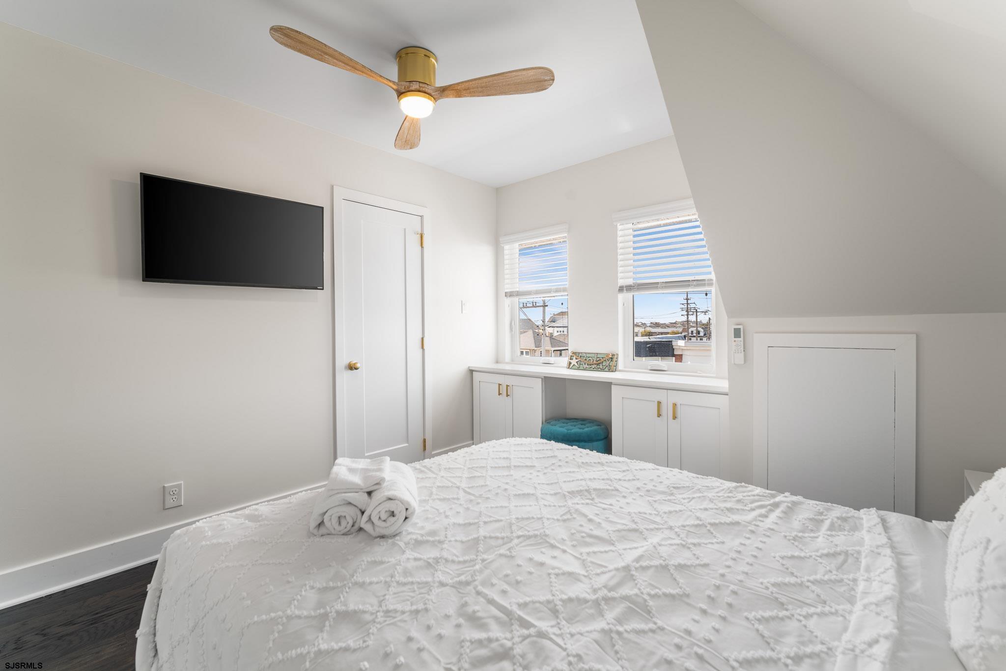 1059 Asbury Avenue, Unit 3 Ocean City, NJ 08226 - Photo 6 of 14 a bedroom with a large bed and a flat tv screen