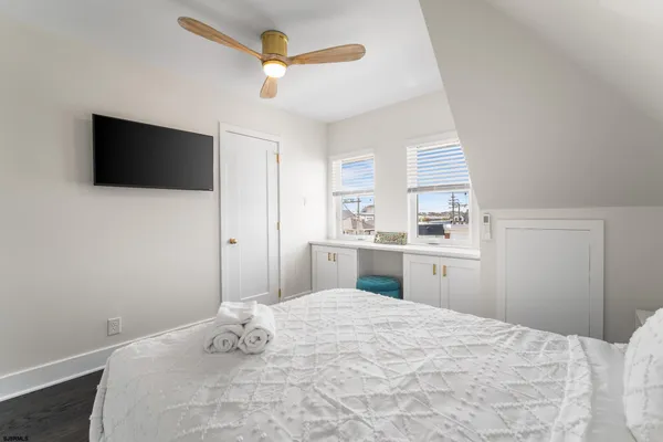 a bedroom with a large bed and a flat tv screen