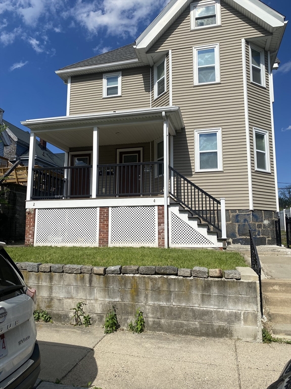 4 Hopestill Street, Unit 1 Boston, MA 02124 - Photo 1 of 5 a view of a white house with large windows and a small yard