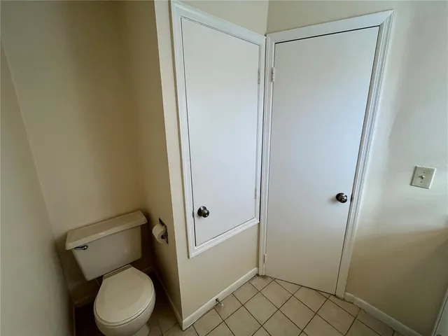 a bathroom with a granite countertop sink toilet and a mirror