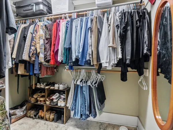 a view of walk in closet with clothes and shoes
