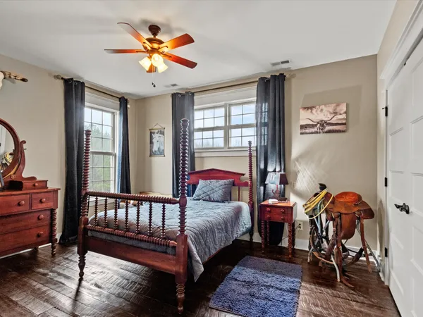 a bedroom with a bed and wooden floor