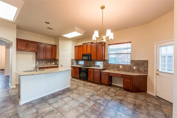 a large kitchen with kitchen island granite countertop a stove and a sink