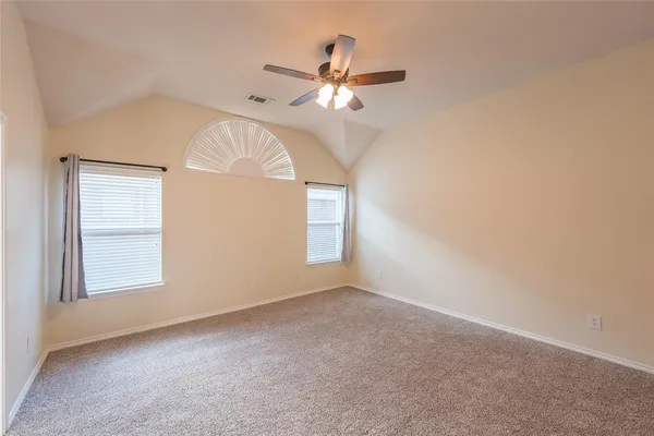 an empty room with windows and fan