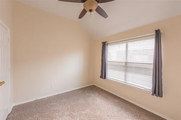 an empty room with an entryway and fan