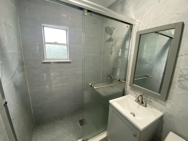 a bathroom with a sink mirror and shower