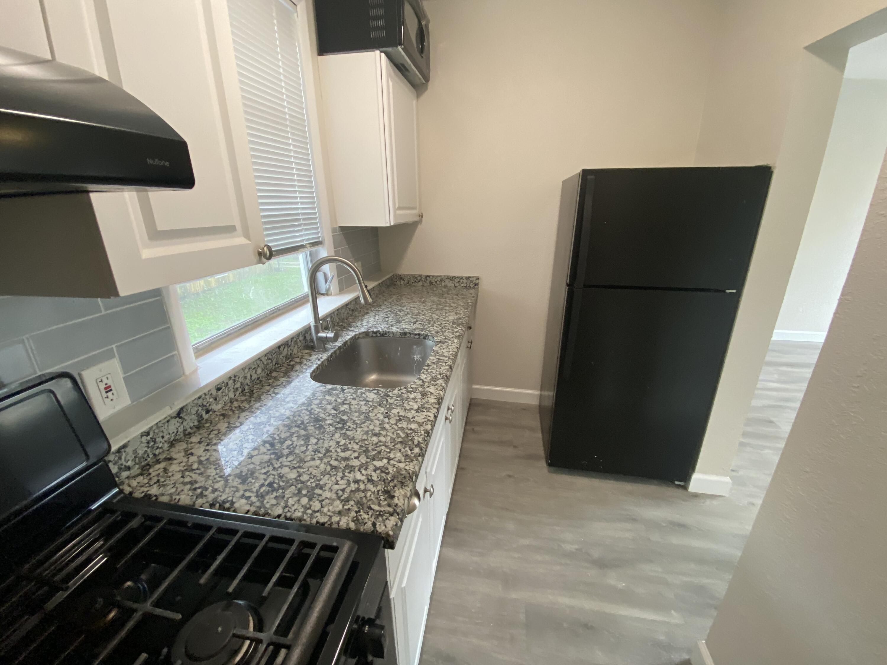 301 South M Street, Unit 5 Lake Worth Beach, FL 33460 - Photo 15 of 17 a kitchen with a sink and a refrigerator