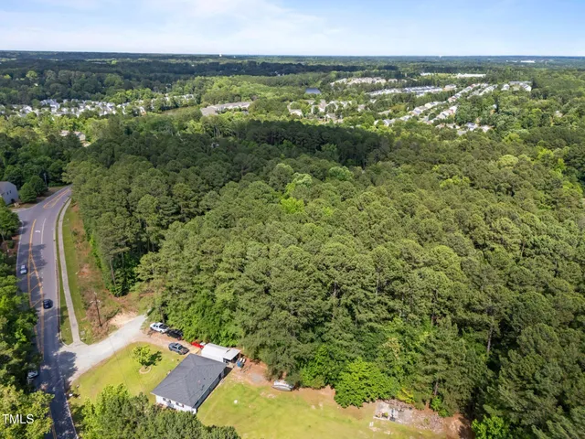 an aerial view of residential houses with outdoor space and ocean view