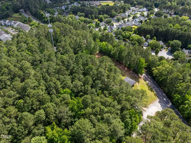 an aerial view of residential houses with outdoor space and trees