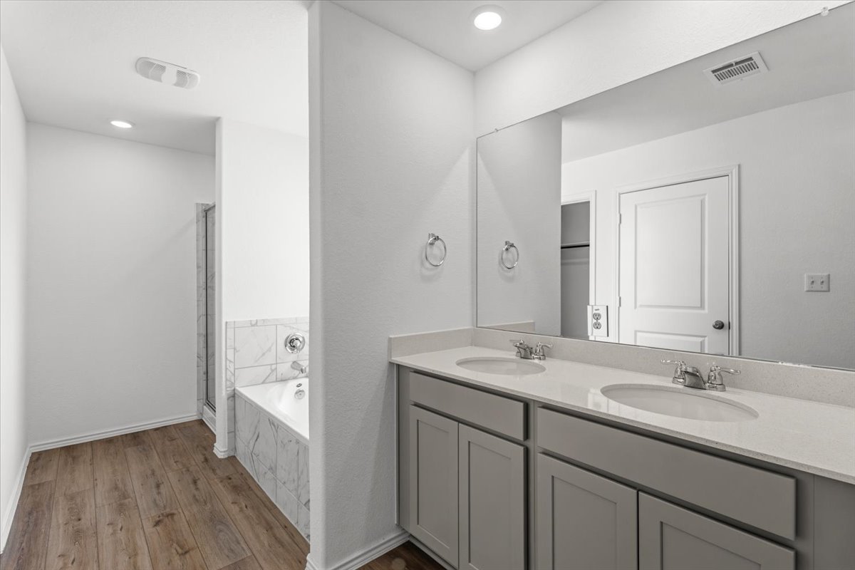 167 Jeffers Kyle, TX 78640 - Photo 24 of 40 Full bathroom with double vanity, a stall shower, dark wood-style floors, a bath, and recessed lighting