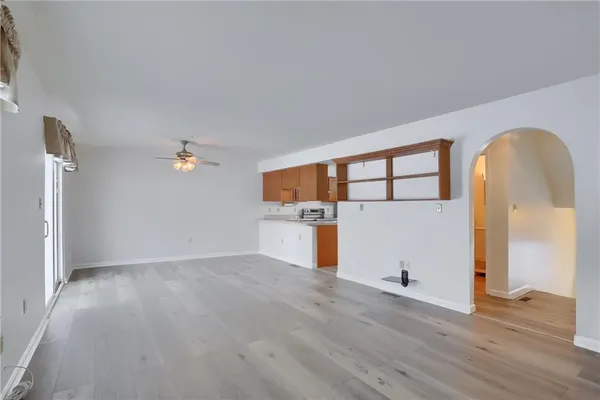 an empty room with wooden floor and entrance