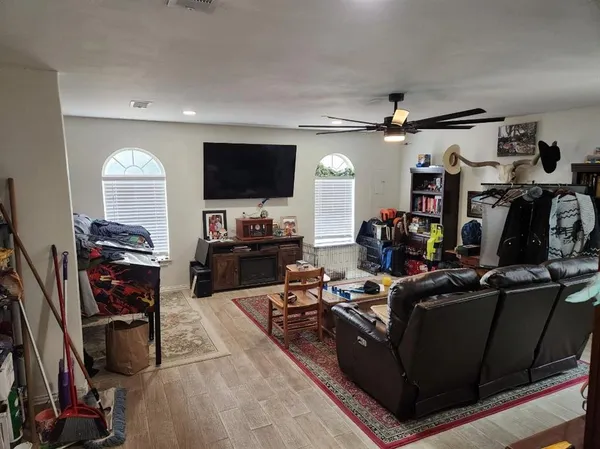 a living room with furniture a flat screen tv and a window